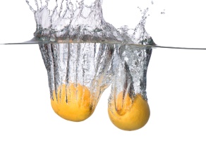 Fresh fruits, lemon falling in water splash, isolated on white background